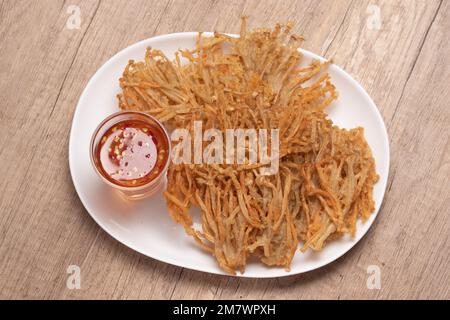 Funghi ad ago dorati fritti con salsa dolce e piccante Foto Stock