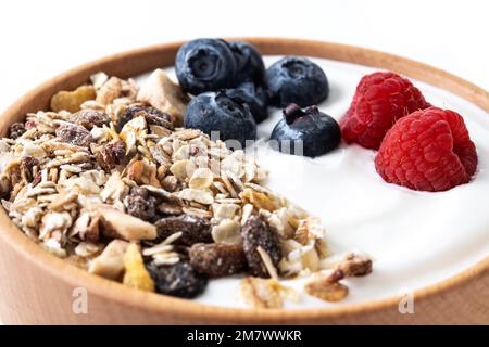 Yogurt con frutti di bosco e muesli per la colazione in ciotola. Primo piano Foto Stock