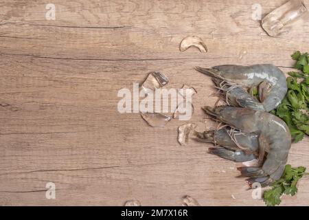 Gamberetti freschi crudi su sfondo di legno Foto Stock