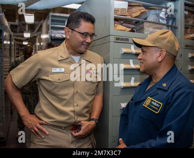 SAN DIEGO (14 maggio 2022) Commander Task Force (CTF) 56 Operations Logistics Officer Rear ADM. Alan Reyes parla con USS Boxer (LHD 4) Supply Department Leading Chief Petty Officer Master Culinary Specialist Victor Chiquito durante una visita pianificata alla nave. Reyes ha visitato Boxer per osservare 10 Stati Uniti Marinai della Riserva Navale assegnati al Naval Supply Systems Command. Foto Stock