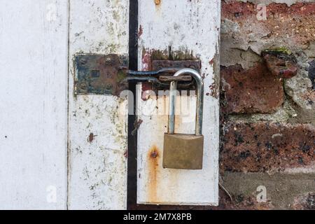 Lucchetto di bloccaggio un lucchetto di acciaio su una porta scorrevole capannone officina, County Down, Irlanda del Nord, Regno Unito, Regno Unito Foto Stock