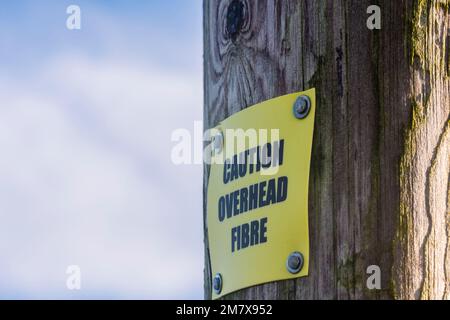 Firma su un palo telefonico di legno che avverte della fibra [ottica] per la banda larga rurale, County Down, Irlanda del Nord, Regno Unito, Regno Unito Foto Stock