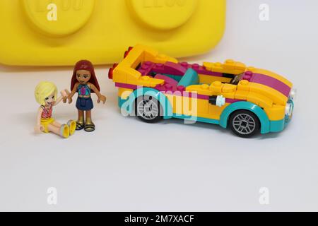 2 mini figure di lego accanto a una macchina sportiva di lego che tiene le mani Foto Stock