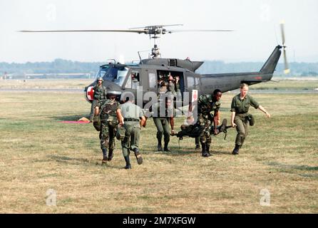 I medici del 32nd Combat Support Hospital trasportano un 'paziente' su una lettiera, da un elicottero Iroquois UH-1 a un Mobile Army Surgical Hospital (MASH) durante il Reforger '82. Subject Operation/Series: REFORGER '82 base: Darmstadt Army Air Field Nazione: Germania Occidentale (FRG) Foto Stock