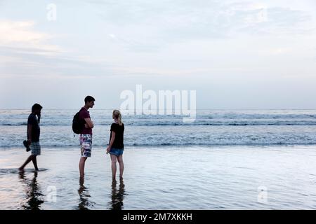 Palolem, India-1 settembre 2012. Un paio di turisti che chiacchierano sulla riva mentre la marea sale e il cielo comincia a tramontare Foto Stock