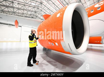 11 gennaio 2023, Brandeburgo, Schönefeld: OLAF Groß, Licence Engineer di easyJet, controlla il livello dell'olio nel motore di un Airbus A320 Neo con una torcia elettrica prima dell'inizio dell'apertura del nuovo hangar di manutenzione easyJet all'aeroporto di Berlino Brandeburgo (BER) 'Willy Brandt'. Il nuovo edificio è il primo hangar easyJet fuori dal Regno Unito. Le operazioni di manutenzione per la flotta easyJet Europe verranno effettuate qui. Foto: Soeren Stache/dpa Foto Stock