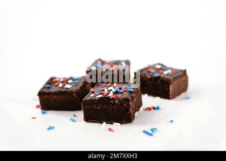 Brownie al cioccolato fondente con spruzzi bianchi blu rosso patriottici su sfondo bianco Foto Stock