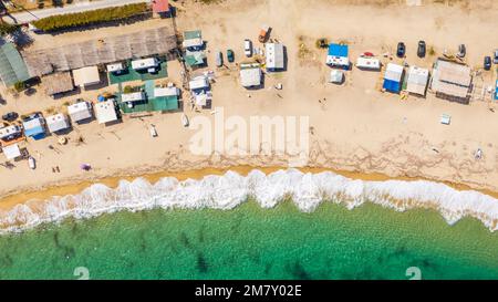 Vista aerea dell'onda che si infrangono nell'oceano con una calda luce al tramonto. Onda che si schiantano sul reef. Vista dall'alto. Foto Stock