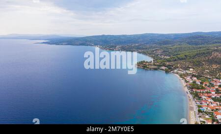 Antenna vista al tramonto di sorprendenti Neos Marmaras cityscape e distante isola della tartaruga in Grecia. Foto Stock