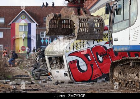 Erkelenz, Germania. 11th Jan, 2023. Un escavatore afferra una carovana durante la bonifica del villaggio di Lützerath. L'azienda energetica RWE vuole scavare il carbone che si trova sotto Lützerath - a questo scopo, il borgo sul territorio della città di Erkelenz presso l'opencast lignite miniera Garzweiler II è da demolire. Credit: Rolf Vennenbernd/dpa/Alamy Live News Foto Stock