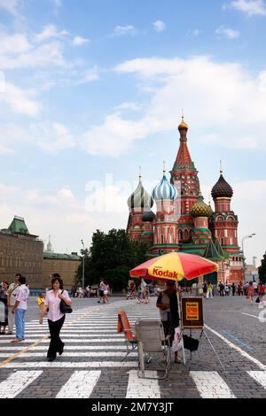 Mosca, Russia-20 luglio 2010. Un fotografo offre servizi di ritratto con St. Cattedrale di Basilio sullo sfondo ai turisti che visitano la S Rossa Foto Stock