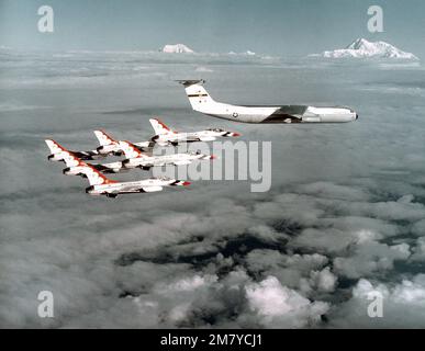 Sopra le nuvole una formazione Delta a sei navi di Thunderbirds F-16AS vola in pista verso uno dei loro aerei di supporto C-141b Starlifter. Paese: Sconosciuto Foto Stock
