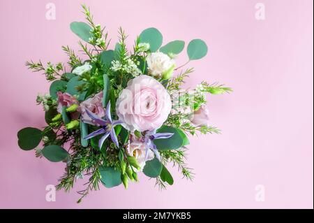 Bouquet di fiori dall'alto su sfondo rosa con spazio copia, biglietto d'auguri femminile per San Valentino, giorno della madri, matrimonio o compleanno, copia Foto Stock