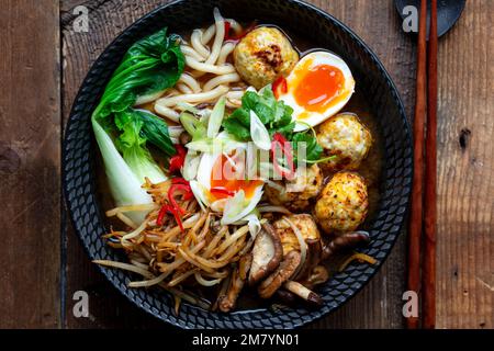 Zuppa di ramen con polpette e tagliatelle di udon Foto Stock