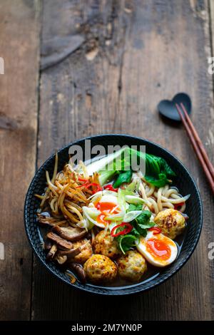 Zuppa di ramen con polpette e tagliatelle di udon Foto Stock