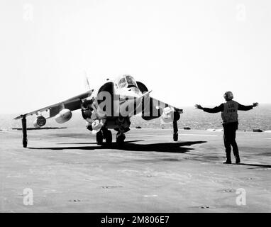 Un equipaggio di ponte di volo segnala al pilota di un aeromobile Marine AV-8C Harrier verticale/corto decollo e atterraggio (V/STOL). La Harrier, prodotta da McDonnell-Douglas, Inc., è sottoposta a un programma di test e valutazione. Paese: Sconosciuto Foto Stock