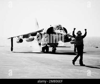 Un equipaggio di ponte di volo segnala al pilota di un aeromobile AV-8C Harrier verticale/corto decollo e atterraggio (V/STOL). La Harrier, prodotta da McDonnell-Douglas, Inc., è sottoposta a un programma di test e valutazione. Paese: Sconosciuto Foto Stock