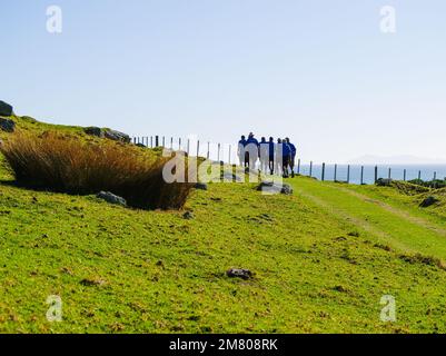 Tauranga Nuova Zelanda - Aprile 30 2010; Editorial-Walking gruppo in silhouette indossando camicie blu a piedi via sul lato Monte Maunganui Foto Stock