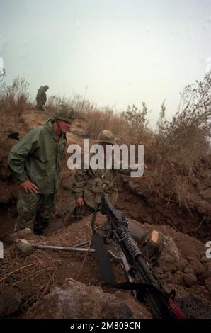 Il maggiore Generale William H. Schneider, comandante della Divisione Fanteria 25th, esamina la buca mitragliatrice M-60 del PFC Thomas Flood, assistente con la Compagnia A, 1st Battaglione, 35th Fanteria, 25th Divisione Fanteria. L'unità di Thomas sta seguendo un programma annuale di addestramento e valutazione dell'esercito presso la Pohakulua Training Area dell'esercito statunitense. Stato: Hawaii (HI) Paese: Stati Uniti d'America (USA) Foto Stock