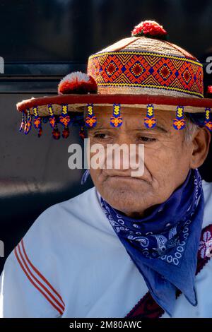 vecchio uomo della cultura wixarika huichol con il suo cappello tradizionale, vendendo il suo artigianato in messico Foto Stock