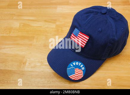 Ho votato un adesivo su un cappello da baseball blu patriottico con la bandiera  americana su sfondo di legno Foto stock - Alamy