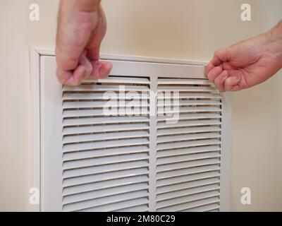 Sostituzione del filtro dell'aria del climatizzatore centrale sporco. Tecnico di riparazione HVAC che esegue la manutenzione dell'impianto di riscaldamento e raffreddamento interno domestico. Foto Stock