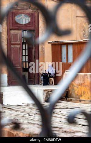 DONNA VELATA CON IL SUO TELEFONO CELLULARE NELLA CITTADELLA DI SALADIN, SALAH EL DIN, COSTRUITA NEL 12TH ° SECOLO, IL CAIRO, EGITTO, AFRICA Foto Stock