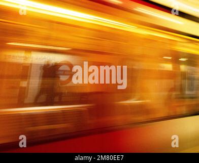 Stazione della metropolitana di Londra Sloane Square, gestita da Tfl (trasporto per Londra); treno della metropolitana che arriva ad alta velocità, l'immagine è sfocata Foto Stock