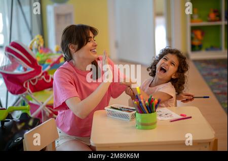 Mamma e bambino in una sala giochi, il bambino piangendo Foto Stock