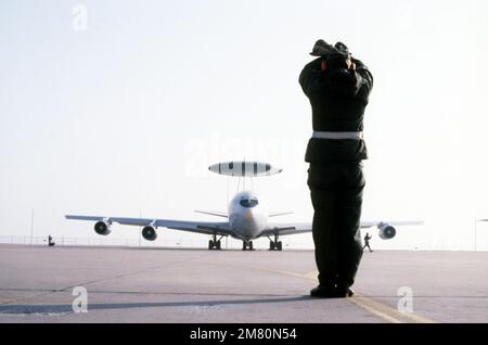 Un membro della 552nd generazione di aerei Squadron marshalls un e-3A Sentry Airborne Warning and Control System (AWACS), assegnato alla 552nd Airborne Warning and Control Wing, sulla pista prima del lancio. L'aeromobile si sta preparando per l'impiego. Base: Tinker Air Force base Stato: Oklahoma (OK) Paese: Stati Uniti d'America (USA) Foto Stock