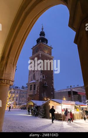 Scena da sotto un arco della medievale Sala di stoffa del mercato di Natale di Cracovia e la Torre del Municipio di notte, la Città Vecchia di Cracovia, Cracovia Polonia Foto Stock