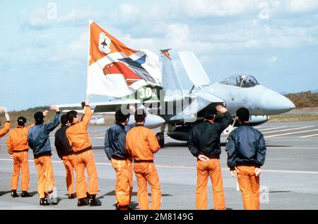 Membri dell'ala aerea 2nd, la forza giapponese di autodifesa aerea (JASDF), WAVE Arrivederci come un aereo F-15 Eagle dal 67th Tactical Fighter Squadron decollo per la base aerea di Kadena, Giappone. Il F-15 sta ritornando alla sua base alla conclusione dell'esercizio congiunto JASDF/US Air Force COPE NORTH 84-1. Oggetto/Serie: COPE NORTH 84-1 base: Chitose Air base Paese: Giappone (JPN) Foto Stock