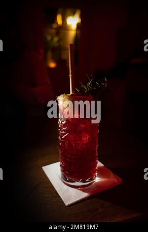 cocktail cranberry fizz in un pub con rosmarino e limone Foto Stock
