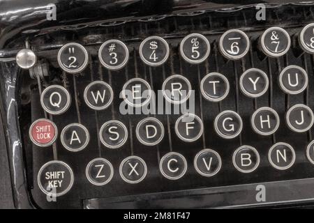 Macchina da scrivere antica che mostra i tradizionali tasti QWERTY. Prima della messaggistica di testo, la gente ha usato i typewriters per comunicare scrivendo le lettere. Foto Stock