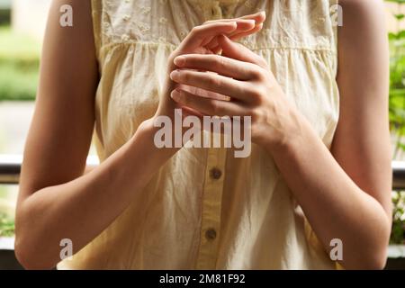 Ragazza adolescente in piedi su un balcone e pratica EFT o tecnica emotiva libertà Foto Stock