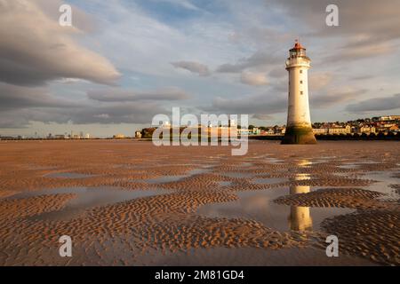 New Brighton, Regno Unito: Faro di Perch Rock riflesso nelle piscine d'acqua con la bassa marea. Un simbolo iconico sulla penisola di Wirral. Foto Stock