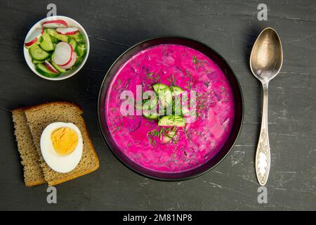 Sana zuppa fredda estiva con barbabietola e crema sul tavolo nero, vista dall'alto. Foto Stock