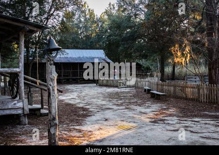 Ampio scatto di un'area agricola con uno spaventapasseri e una campana in primo piano e sullo sfondo Foto Stock