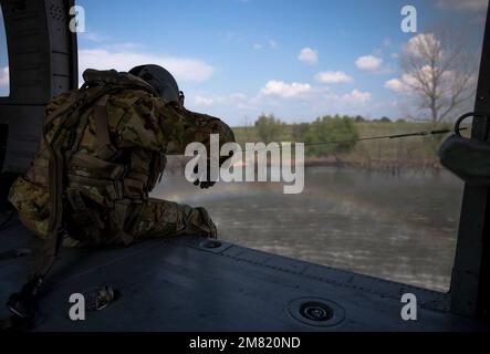 Un capo dell'equipaggio di Bravo Company, 2/147th Battaglione dell'elicottero d'assalto, osserva il movimento di un secchio di bambi mentre è abbassato in acqua durante l'addestramento del secchio d'acqua al Wendell H. Ford Regional Training Center a Greenville, Ky., 19 luglio 2021. L'estinzione aerea consente al personale di volo di spostare l'acqua in un secchio sospeso dall'elicottero e rilasciarla sul sito di un incendio quando richiesto. (STATI UNITI Foto della Guardia Nazionale militare di SPC. Danielle Sturgill) Foto Stock