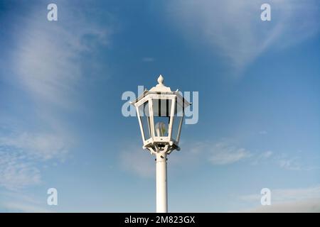 Primo piano della vecchia lampada da strada bianca isolata sul cielo blu Foto Stock