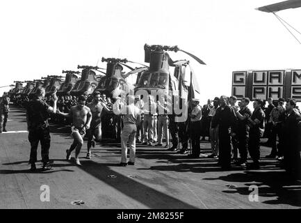 Faulkner, 22nd MAU comandante ufficiale, e il capitano J. M. Quarterman, USS GUAM (LPH 9) comandante offier, accettano le bandiere dei corridori finali mentre attraversano il traguardo durante la GUAM 'Run Sross the Atlantic'. La maratona trans-atlantica è iniziata il 20th aprile a Rota, in Spagna, e si è conclusa il 1st maggio entro il limite di 3 miglia vicino a Morehead City, North Carolina. Una fila di cavalieri marini CH-46 sono sul ponte. Base: USS Guam (LPH 9) Nazione: Oceano Atlantico (AOC) Foto Stock