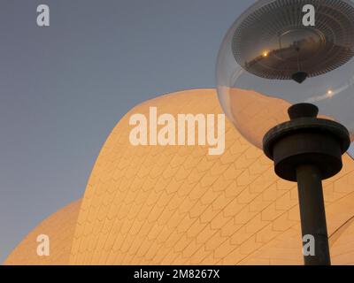 Una lampada di fronte alla Sydney Opera House riflette lo skyline della città, Australia - Foto Stock