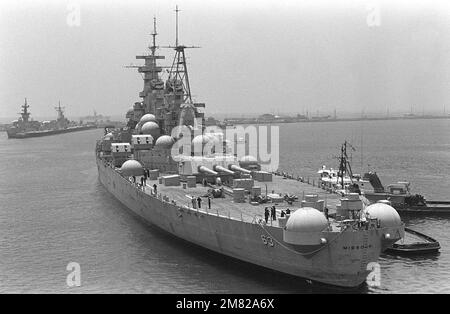 Tugs guida la nave da guerra MISSOURI (BB 63) verso il molo del cantiere navale di Long Beach, dove sarà sottoposta a ristrutturazione/ristrutturazione. Notare gli 'igloos' utilizzati per proteggere i supporti della pistola da 40 mm mentre la nave era in riserva. Base: Long Beach Stato: California (CA) Paese: Stati Uniti d'America (USA) Foto Stock