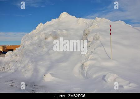 Grande mucchio di neve nel parcheggio del centro commerciale a seguito di una forte tempesta di neve di dicembre. Foto Stock