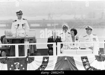 Capitano Fredrik H.M. Spruitenburg, comandante del sottomarino ad attacco nucleare USS HYMAN G. RICKOVER (SSN 709), interviene durante la cerimonia di messa in servizio della nave presso la General Dynamics Electric Boat Division. Seduti a destra, sono, da sinistra a destra: Il Vice Ammiraglio in pensione Hyman G. Rickover; Eleonore Rickover, sponsor; il Comandante tenente James M. Leone, Chaplain Corps; e il Vice Ammiraglio Nils R. Thunman, Vice CAPO delle operazioni Navali, Submarine Warfare. Base: Naval Submarine base, Groton Stato: Connecticut (CT) Paese: Stati Uniti d'America (USA) Foto Stock