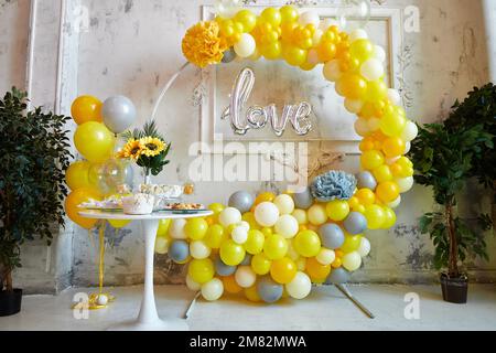 Photozone da palloncini gialli e grigi. Feste di compleanno, matrimonio, fidanzamento, doccia per bambini. Festa decorata con palloncini Foto Stock