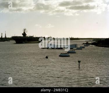 Un'elevata vista di prua portuale della portaerei a energia nucleare USS CARL VINSON (CVN 70) che viene assistito oltre l'USS Arizona Memorial da rimorchiatori. I membri dell'equipaggio presiuono la ferrovia. Base: Pearl Harbor Stato: Hawaii (HI) Paese: Stati Uniti d'America (USA) Foto Stock