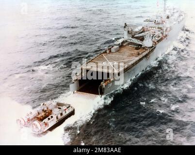 Una vista laterale a dritta di un cuscino d'aria dell'imbarcazione di atterraggio (LCAC 001) che si avvicina al ponte dei pozzi della nave di sbarco USS PENSACOLA (LSD 38) durante il primo accoppiamento in corso tra una LCAC e una LSD. L'LCAC sta trasportando un veicolo di atterraggio cingolato LVTP7. (Immagine substandard). Nazione: Golfo del Messico Foto Stock