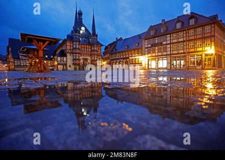 Wernigerode, Germania. 12th Jan, 2023. Il municipio di Wernigerode si riflette in una pozza di pioggia sulla piazza del mercato la mattina presto. Il tempo piovoso domina il giorno in Sassonia-Anhalt. Gli incantesimi secchi sono rari. Si suppone che nei prossimi giorni si raffredderà un po'. Credit: Matthias Bein/dpa/Alamy Live News Foto Stock