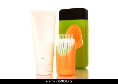 Auricolari, crema cosmetica e shampoo in contenitori di plastica, macro, isolati su fondo bianco. Foto Stock